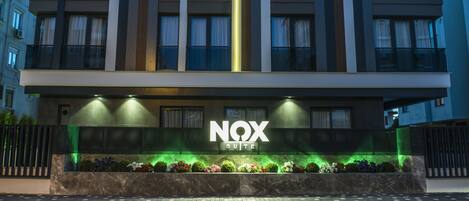 A modern building with a sign reading "NOX SUITE".