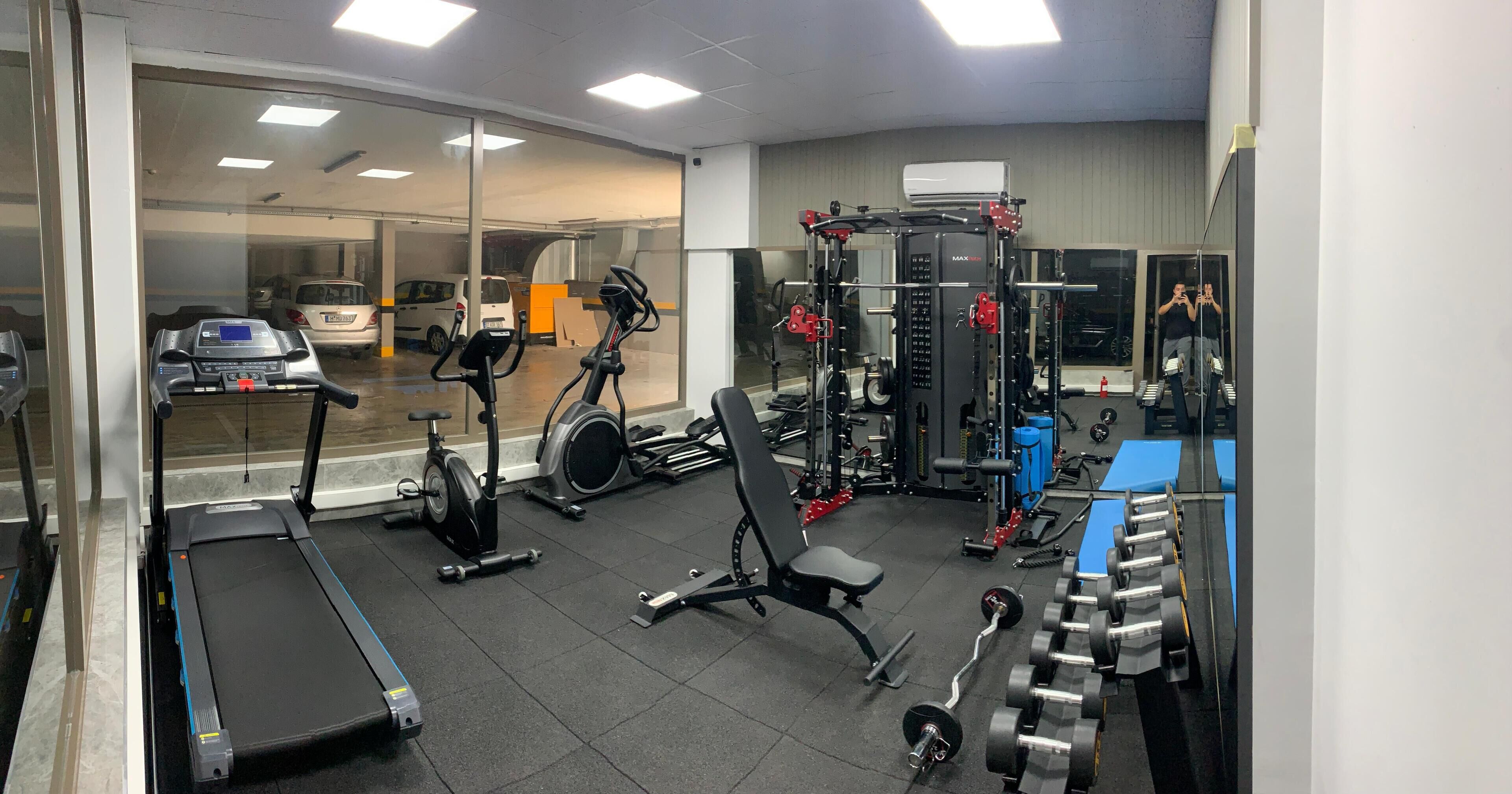 A gym with treadmills, stationary bikes, a squat rack, and free weights.