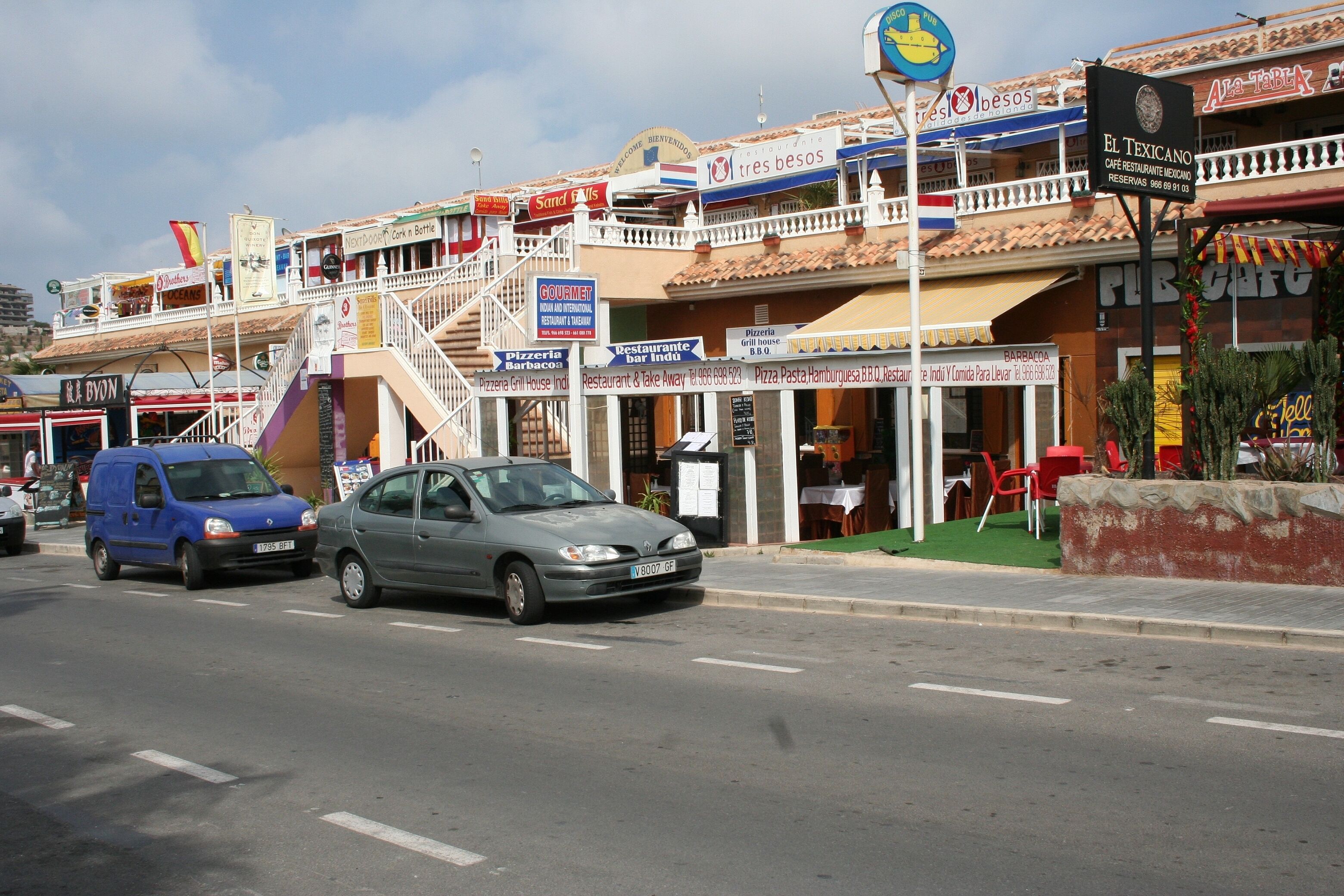 Eine Straßenszene mit mehreren Restaurants und einer Pizzeria.