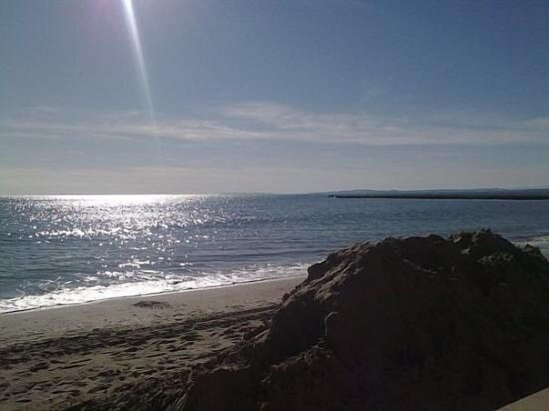 A beach with a clear sky and calm sea.