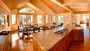 A spacious kitchen with a large island, wooden cabinets, and a view of the outdoors.