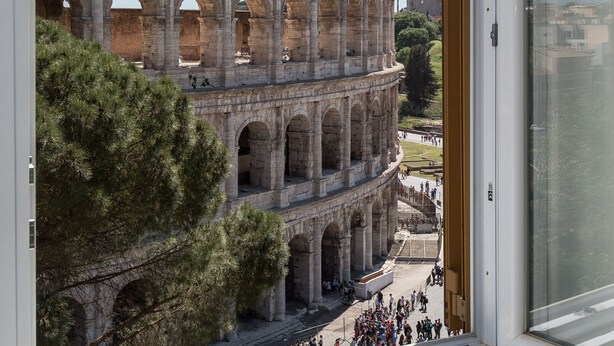 A view of the Colosseum with tourists in the foreground. - Amazing Colosseo (Rome)
