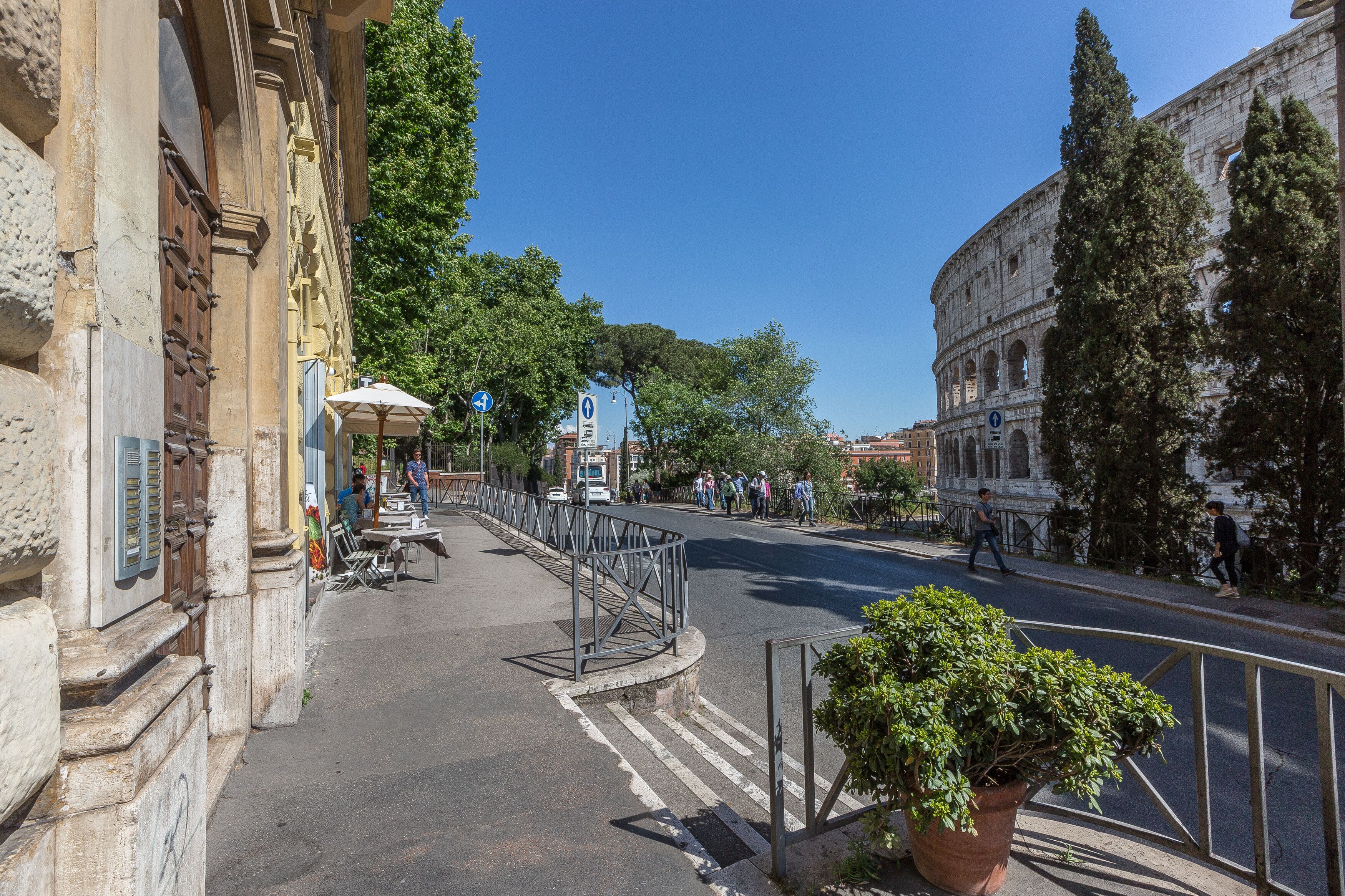 A street with historical buildings, a pedestrian bridge, and a clear blue sky.