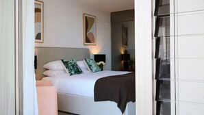 A modern bedroom with a large bed, a bedside table, a chair, and a TV. - Sky Pad by Contemporary Hotels (DARLINGHURST)