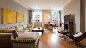 Un salon moderne avec un canapé, une table basse et un téléviseur.