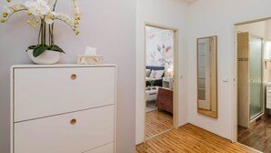 A hotel room with a white dresser, a mirror, and a wooden floor. - APT Prague Ch. Bridge by Michal&Friends (Prague)