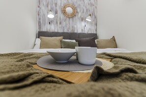 A neatly made bed with a grey and white color scheme, a wooden headboard, and a decorative wall piece above it. - APT Prague Ch. Bridge by Michal&Friends (Prague)
