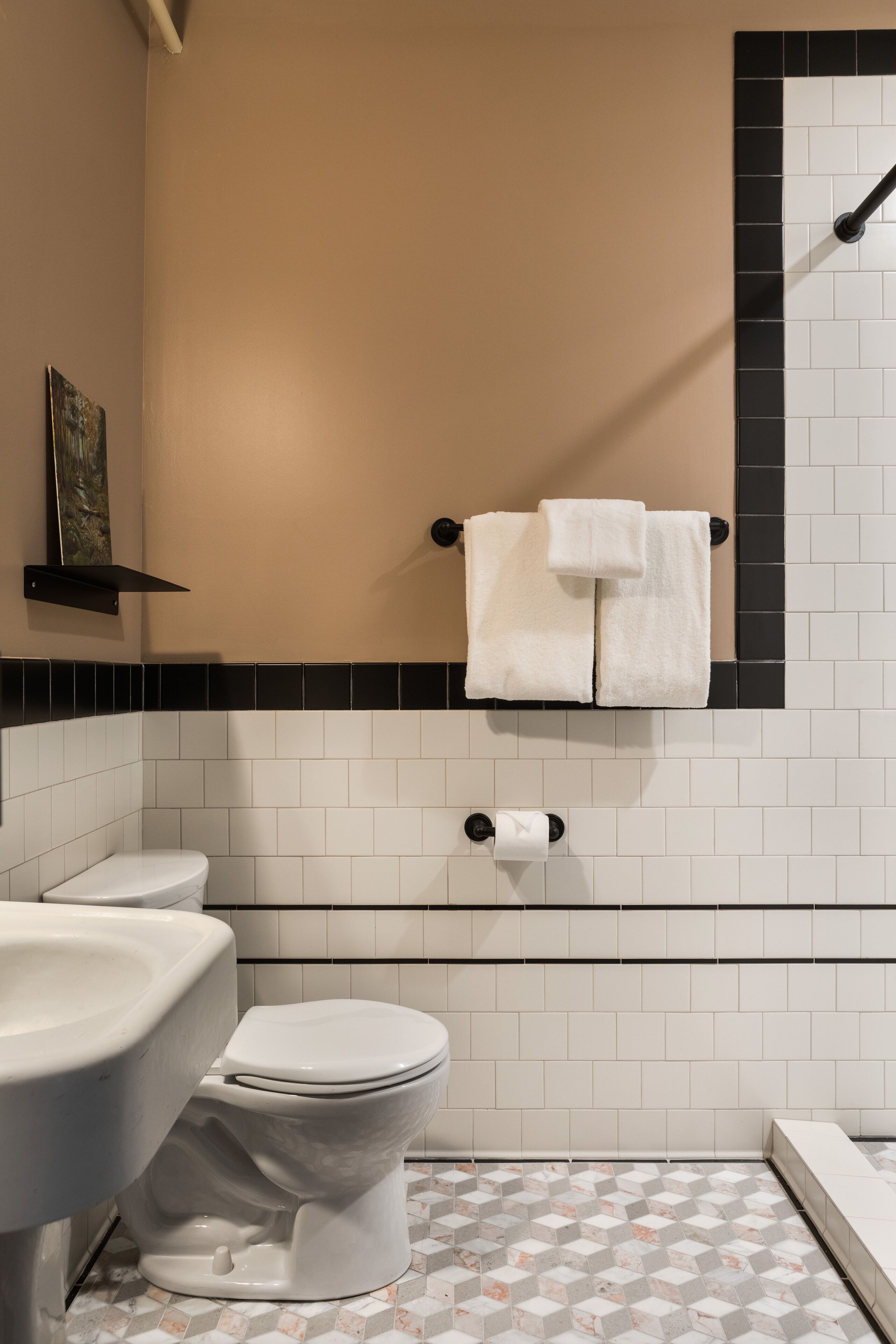 A bathroom with a toilet, sink, and towel rack.