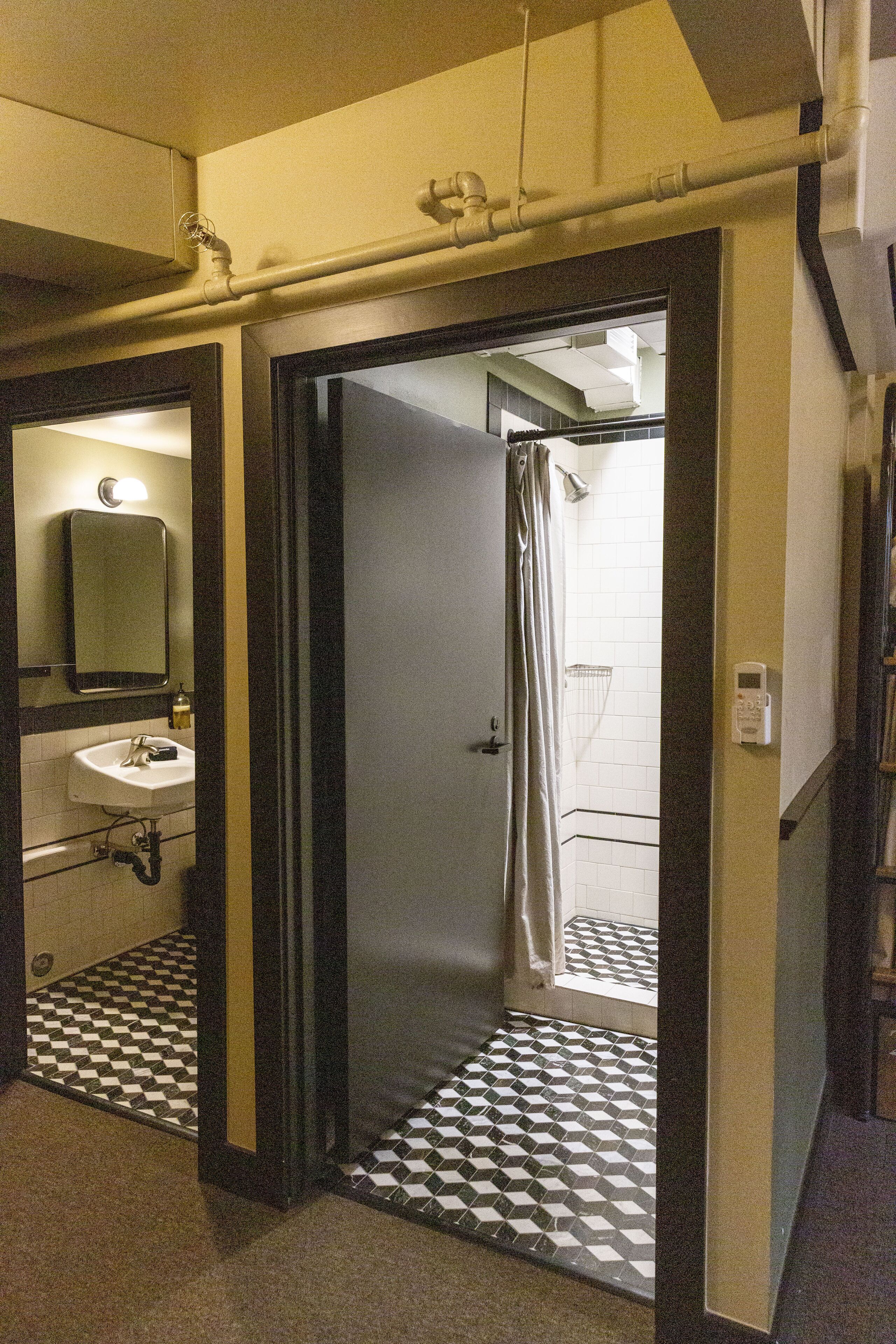 A bathroom with a sink, mirror, and a shower area.