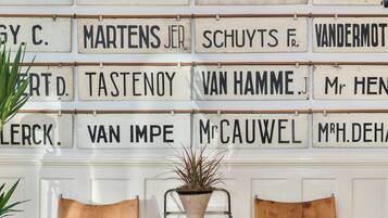 A wall with nameplates and two leather chairs in a room.