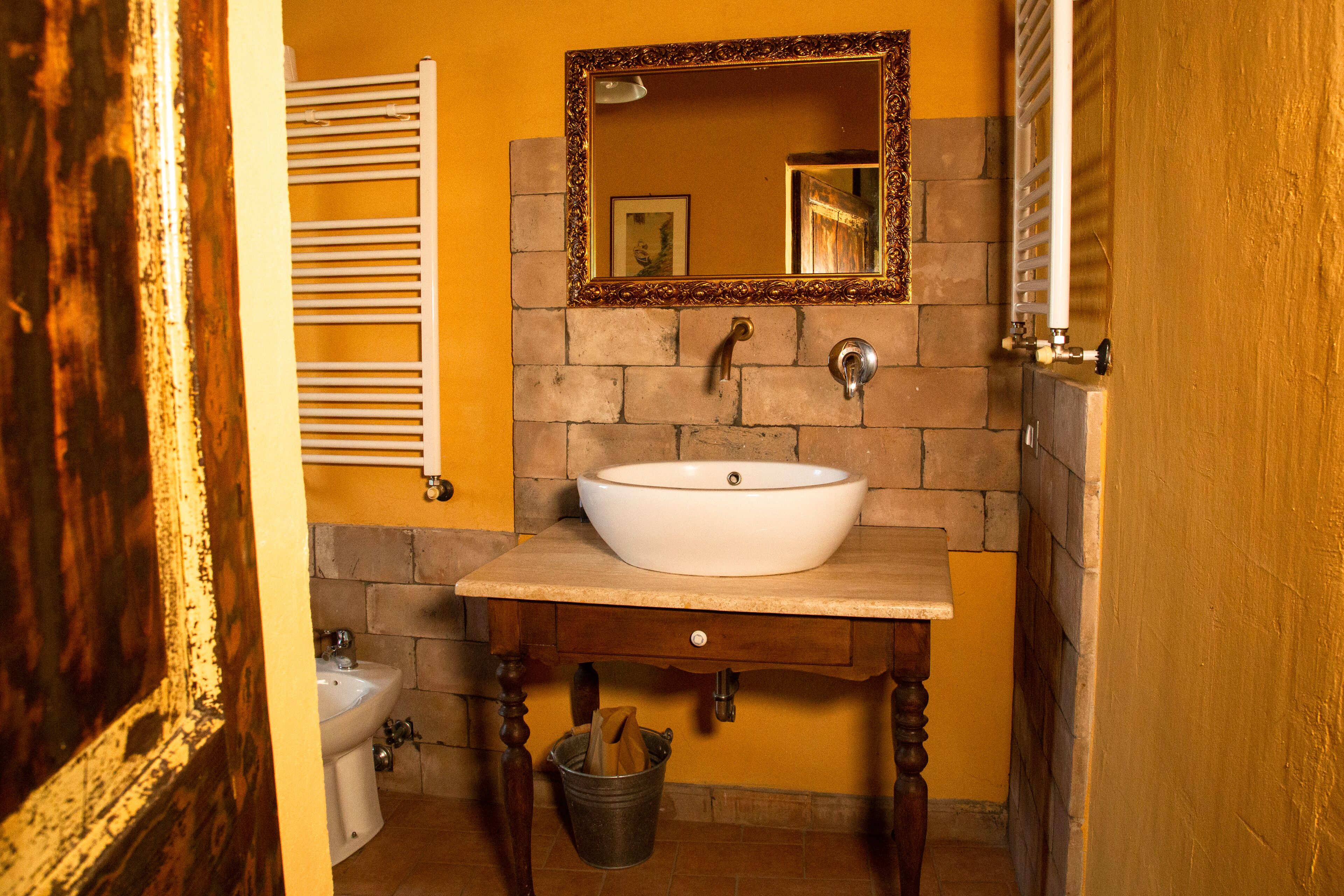 Un baño con un lavamanos blanco, un espejo y un toallero.