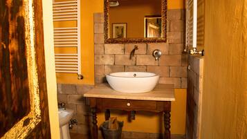 Un baño con un lavamanos blanco, un espejo y un toallero.