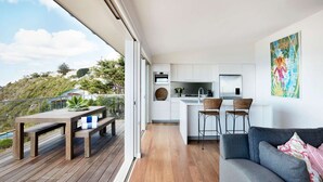 Un apartamento moderno con balcón, cocina y sala de estar.