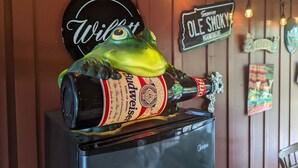 Ein Kühlschrank mit einer Budweiser-Flasche und einem Bierkrug in Froschform darauf.