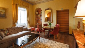 Une pièce comprenant un canapé, une table basse, une table à manger avec des chaises, un miroir et une lampe.