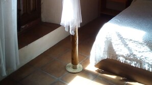 Ein Schlafzimmer mit einem Bett, einem Fenster und einem Nachttisch.