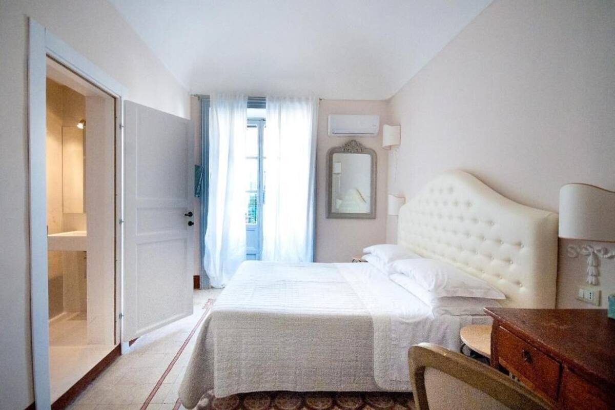Una habitación de hotel con cama, escritorio, silla y armario.