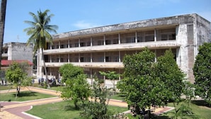 A multi-story building with a central courtyard, surrounded by greenery and palm trees. - Mini Hotel (Phnom Penh)