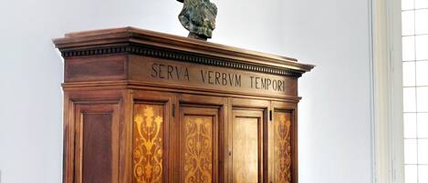 Un gabinete de madera con un busto encima y la inscripción “SERVA VERBVM TEMPOR”.