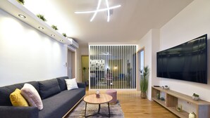 A modern living room with a sofa, coffee table, and TV. - Apartment First Choice Ilica (Zagreb)