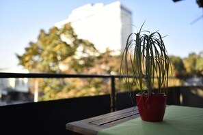 A potted plant on a balcony with a view of trees and a building in the background. - Vla Vla Apartments (Zagreb)