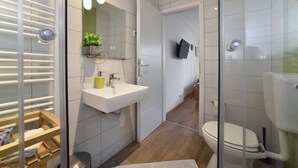 A modern bathroom with a white sink, mirror, and toilet. - Vla Vla Apartments (Zagreb)