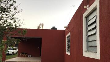 Stylish building with a flat roof and a chimney, featuring a white-framed window.