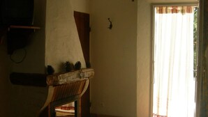 Una habitación con chimenea, televisor montado en la pared y una puerta que da al exterior.