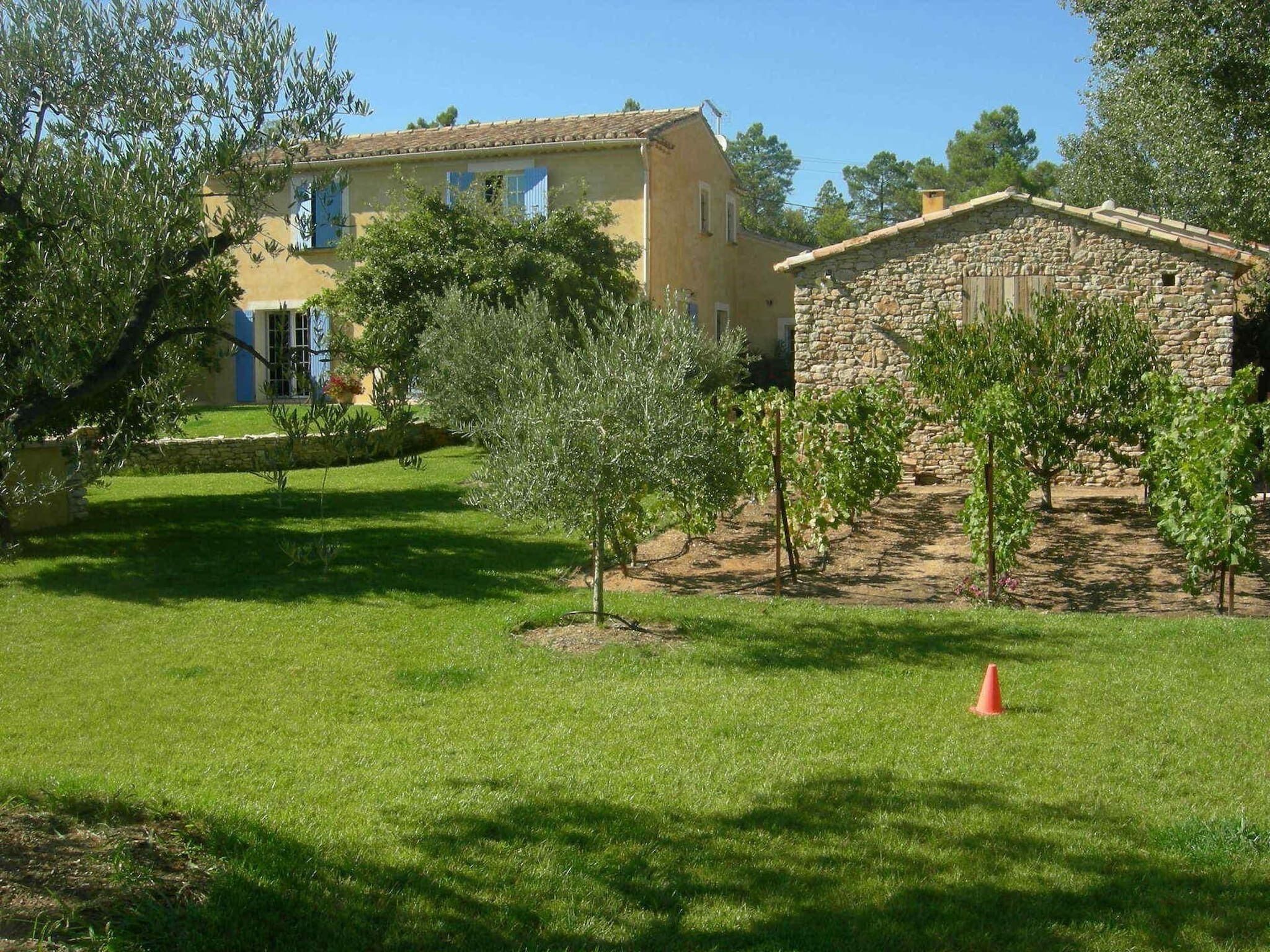 Una casa con un muro de piedra y un césped cuidado.