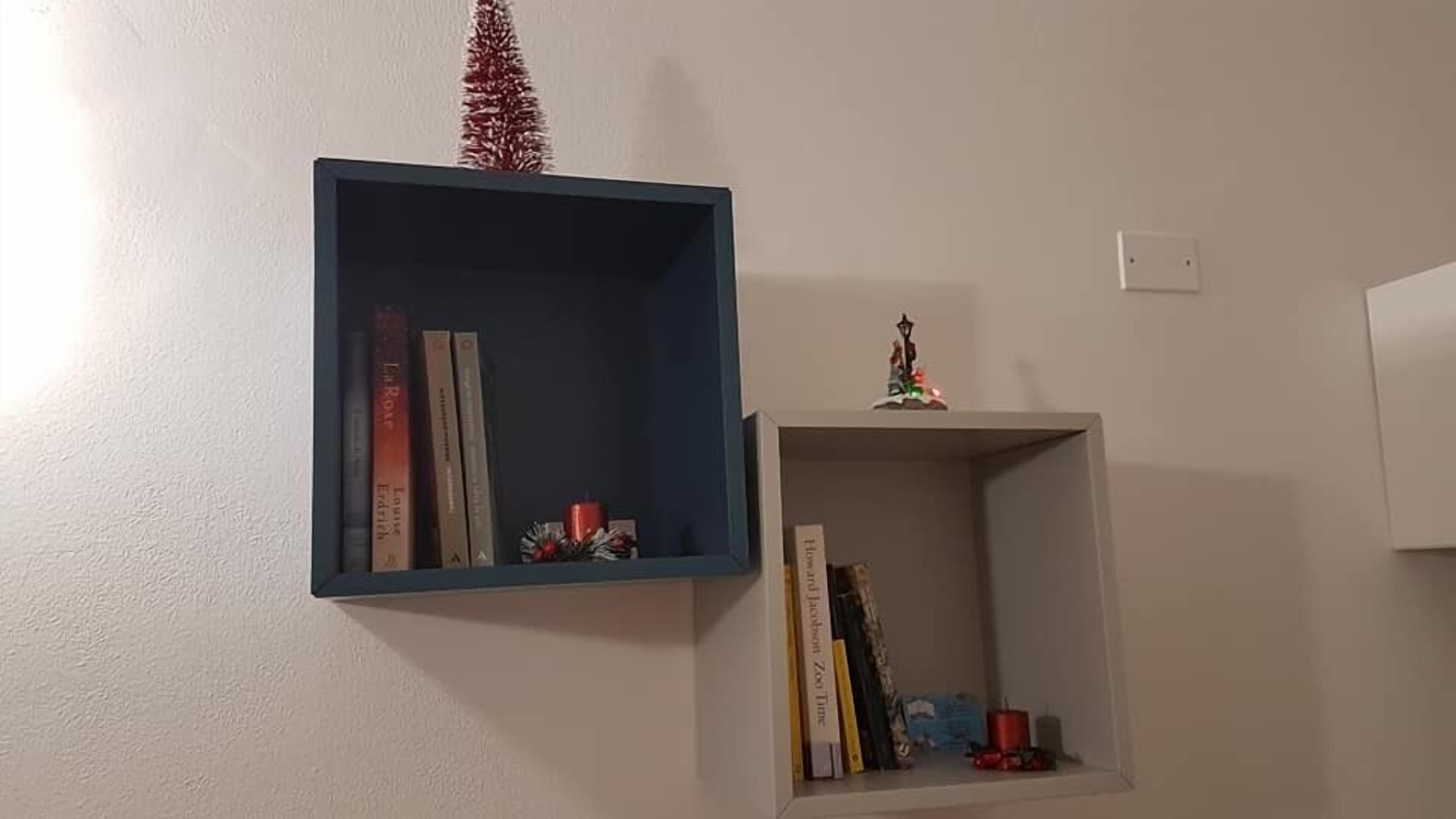 A wall-mounted shelf with books and a small decorative item.