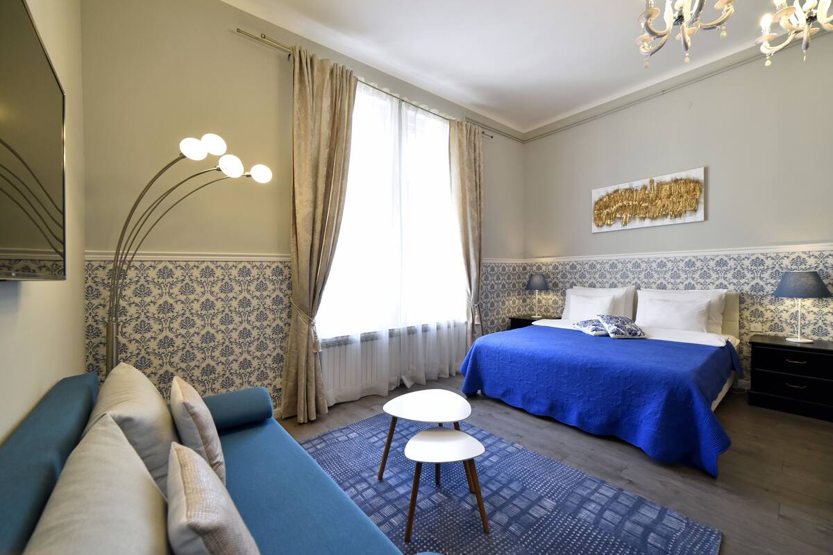 Ein Schlafzimmer mit einem Bett, einem Nachttisch, einem Sessel und einem Spiegel.