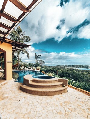 A pool area with a hot tub, lounge chairs, and a view of the ocean and hills. - Luxury Ocean View Villa, Breakfast, Shuttle & 5-Star Service Included ⭐️⭐️⭐️⭐️⭐️ (Samara Beach)