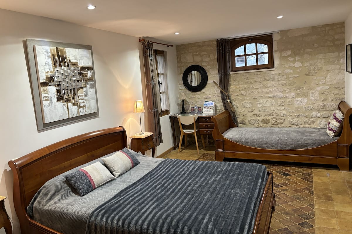 A bedroom with a bed, a desk, and a chair.