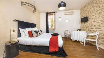 Une chambre à coucher avec un lit, une lampe de chevet et une petite table avec une chaise.