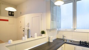 A modern kitchen with a built-in washer, a sink, and a window above the countertop. - First Choice Centar Apartments (Zagreb)