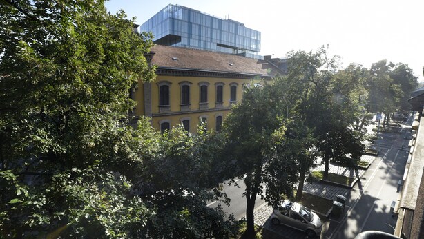 A yellow building with arched windows and a modern glass structure above. - First Choice Centar Apartments (Zagreb)
