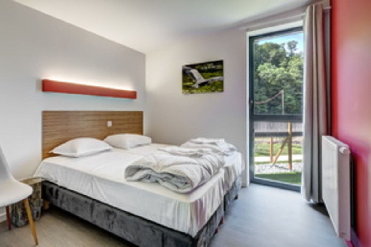Een moderne slaapkamer met een bed, een stoel en een raam.