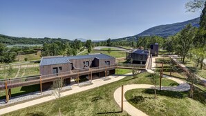 Un bâtiment moderne doté d’un toit plat, entouré d’un espace paysager aménagé avec des allées et un petit pont.
