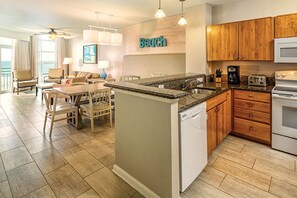 Une cuisine moderne avec des meubles en bois, un lave-vaisselle encastré et un plan de travail en granit.