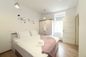A bedroom with a bed, a wardrobe, a mirror, and a wall with a decorative phrase. - First Choice Centar - Primorska (Zagreb)