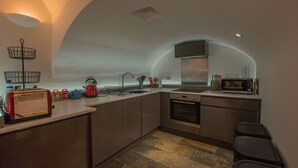 A compact kitchen with a toaster, kettle, and microwave. - Lancaster Apartment - Central Tenby (Tenby)
