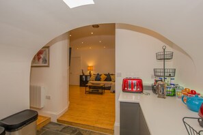 A kitchen with a toaster, a kettle, and a fruit bowl.