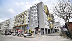 A multi-story building with a parking lot in front. - Botanic Apartment (Zagreb)