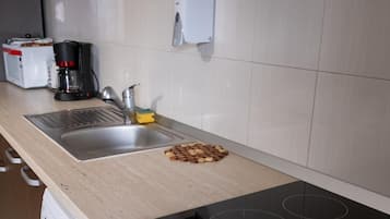 Departamento básico, vista a la ciudad | Cocina privada | Refrigerador con congelador, microondas y parrilla de estufa