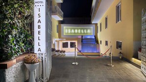 A hotel entrance with a sign reading "ISABELLA HOTEL" and a neon sign above the entrance. - Hotel Isabella (Sant'Agnello)