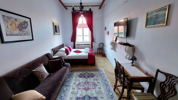 A bedroom with a bed, a sofa, a table, and a chair. - Classical Budapest apartment in the old Pest (Budapest)