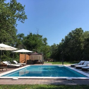 Een seizoensgebonden buitenzwembad en parasols bij het zwembad