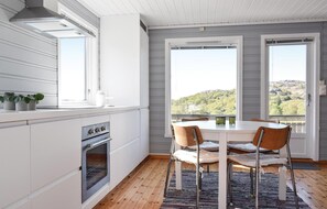 Enjoy meals in this kitchen with a central island, oven, and range hood, offering a view of the surrounding mountains.