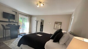 Une chambre à coucher comprenant un lit, une table de chevet, une lampe et un bureau avec une chaise.