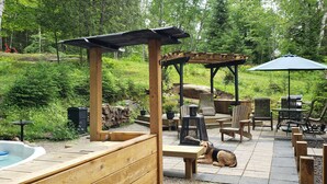 Une terrasse en bois avec un jacuzzi, du mobilier d’extérieur et une pergola.